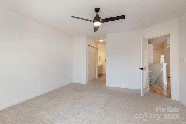 unfurnished bedroom with ensuite bathroom, a closet, ceiling fan, and light colored carpet