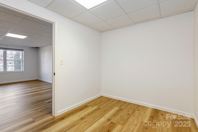 spare room featuring a paneled ceiling and wood-type flooring