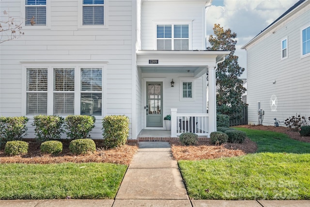 view of exterior entry featuring a lawn