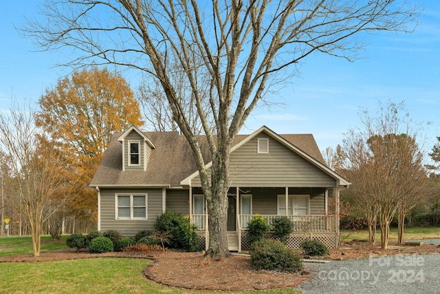 view of front of home with covered porch and a front lawn