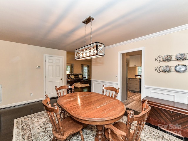 dining room with crown molding and light wood-type flooring