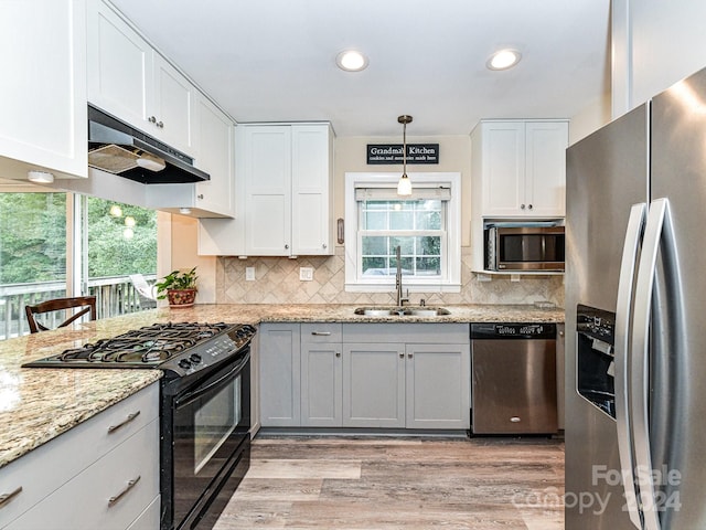 kitchen with white cabinets, pendant lighting, sink, and stainless steel appliances