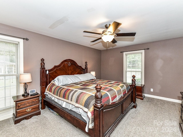 carpeted bedroom with ceiling fan and multiple windows