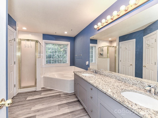 bathroom with wood-type flooring, vanity, and independent shower and bath