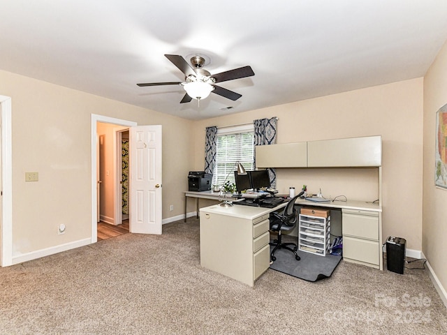 carpeted office space featuring ceiling fan