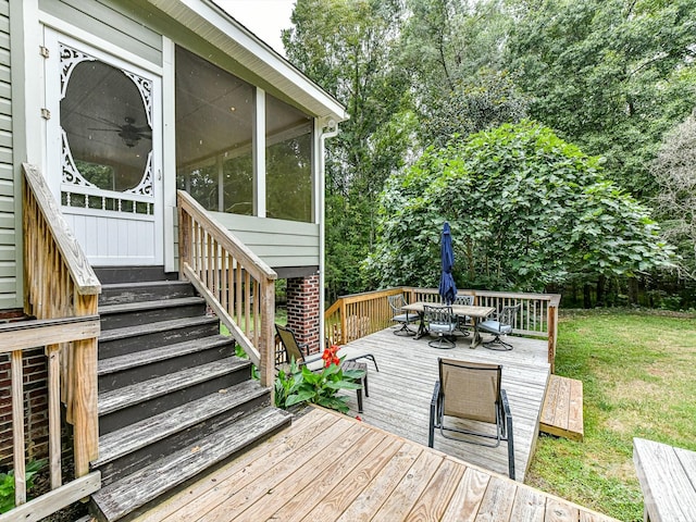 wooden deck featuring a yard and a sunroom