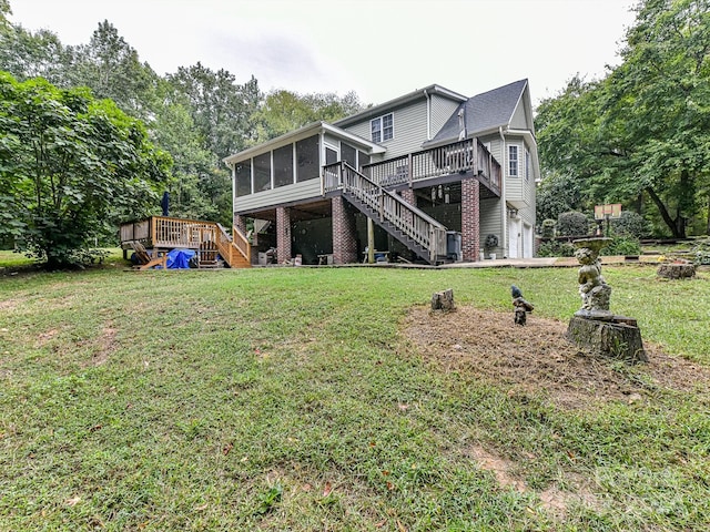 back of property featuring a lawn, a sunroom, a deck, and a garage