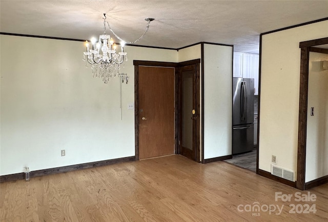 interior space with a chandelier, crown molding, light hardwood / wood-style floors, and a textured ceiling