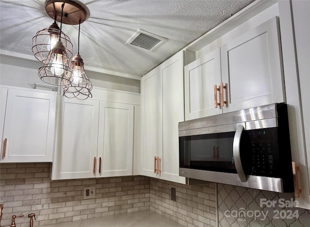 interior details featuring white cabinetry and tasteful backsplash