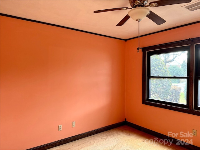 empty room featuring ceiling fan, crown molding, and light hardwood / wood-style flooring