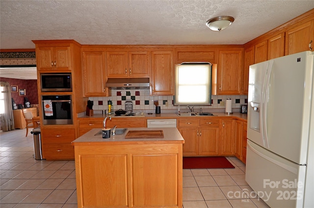 kitchen featuring a center island with sink, light tile patterned flooring, sink, and stainless steel appliances