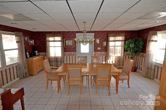 dining space featuring light tile patterned flooring and a chandelier