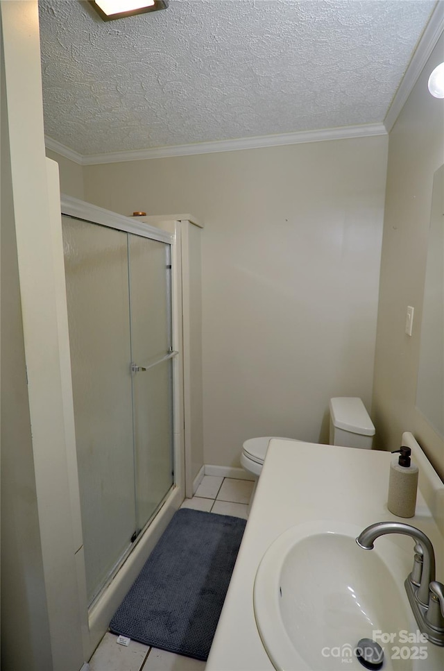 bathroom featuring tile patterned flooring, toilet, walk in shower, and sink