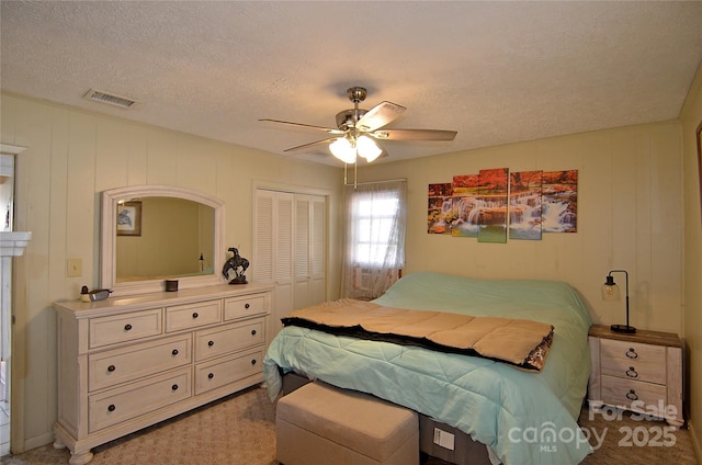 bedroom with carpet flooring, a textured ceiling, a closet, and ceiling fan