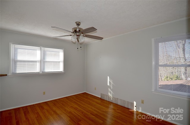 spare room featuring ceiling fan, hardwood / wood-style floors, crown molding, and a textured ceiling