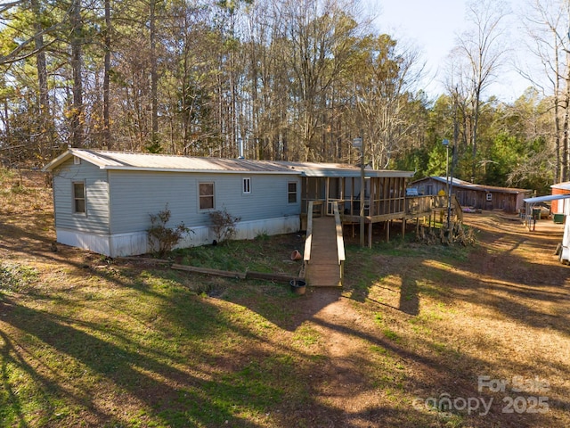 rear view of property with a lawn and a wooden deck