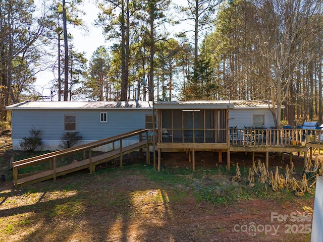 back of house featuring a deck and a sunroom