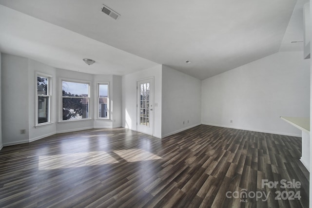 unfurnished living room with dark hardwood / wood-style floors and vaulted ceiling