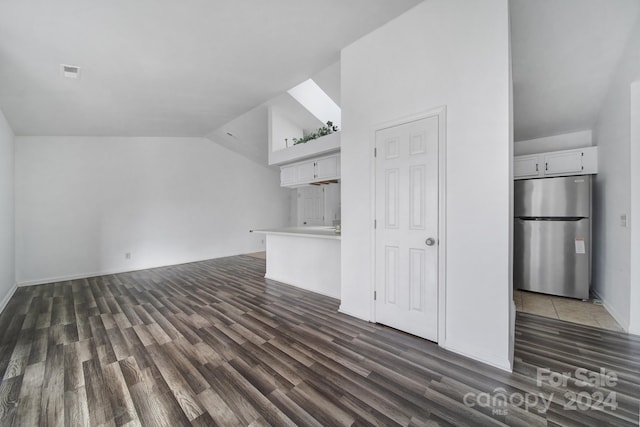 unfurnished living room featuring high vaulted ceiling and dark wood-type flooring