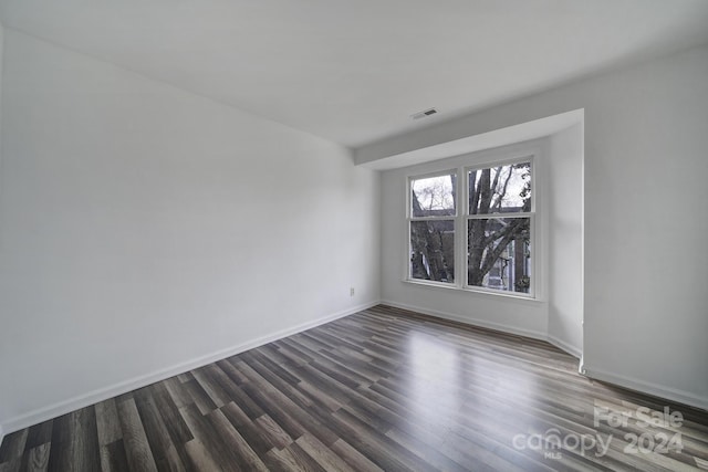 spare room with dark wood-type flooring