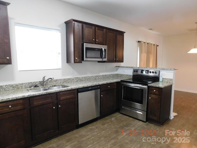 kitchen featuring light stone countertops, sink, appliances with stainless steel finishes, and dark hardwood / wood-style floors