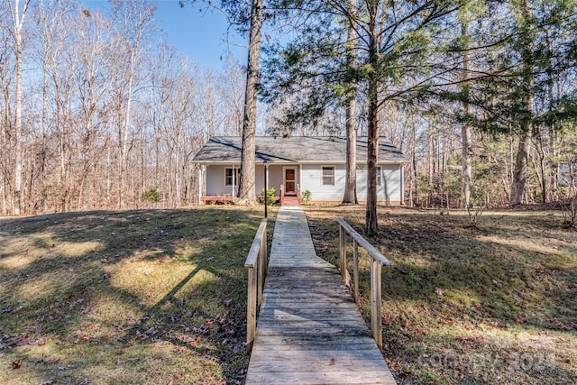 ranch-style house featuring covered porch and a front yard