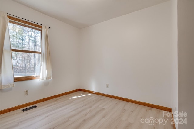 empty room with a wealth of natural light and light wood-type flooring