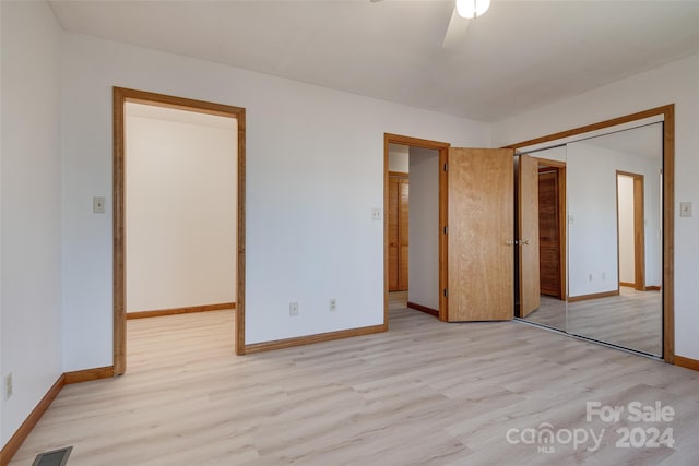 unfurnished bedroom with ceiling fan, light hardwood / wood-style floors, and a closet