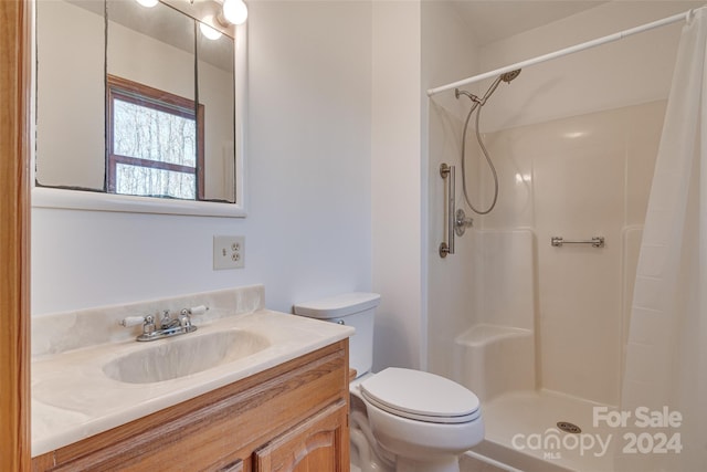 bathroom featuring toilet, vanity, and walk in shower