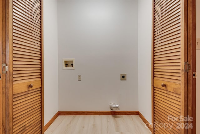 clothes washing area featuring electric dryer hookup, hookup for a washing machine, and light hardwood / wood-style flooring