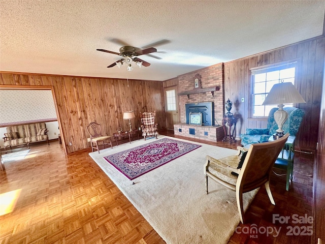 living room featuring parquet floors, ceiling fan, and a textured ceiling