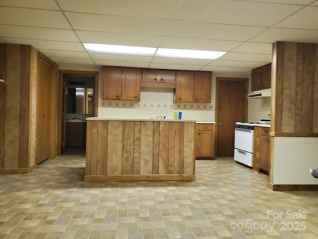 kitchen featuring white gas stove and a drop ceiling