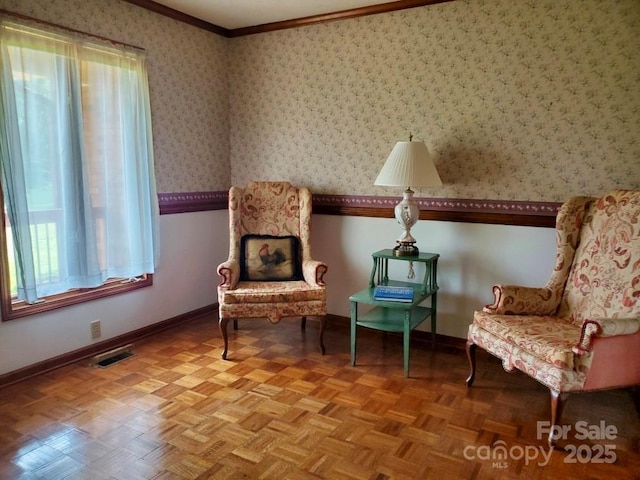 sitting room featuring baseboards, visible vents, ornamental molding, and a wealth of natural light