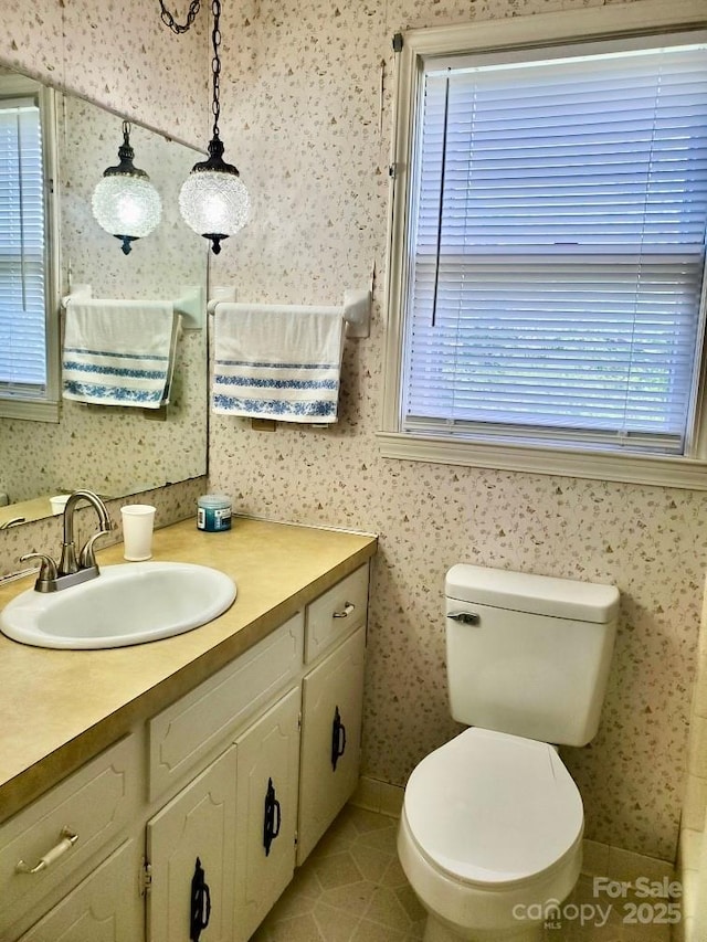 bathroom featuring plenty of natural light and wallpapered walls