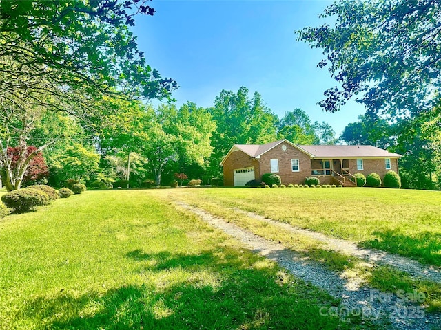 view of front of home featuring a garage, driveway, a front lawn, and brick siding