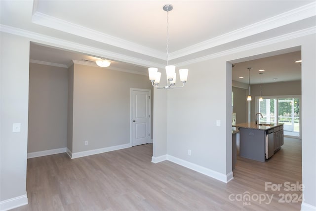 empty room featuring sink, light hardwood / wood-style floors, a notable chandelier, and ornamental molding