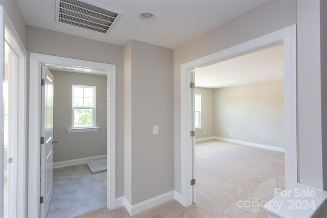 hallway featuring light colored carpet