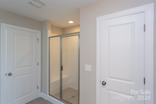 bathroom featuring tile patterned flooring and a shower with shower door