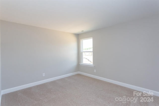 unfurnished room featuring light colored carpet