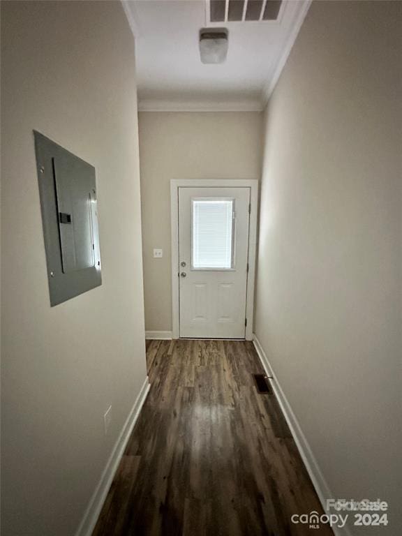 doorway to outside with electric panel, dark hardwood / wood-style floors, and ornamental molding