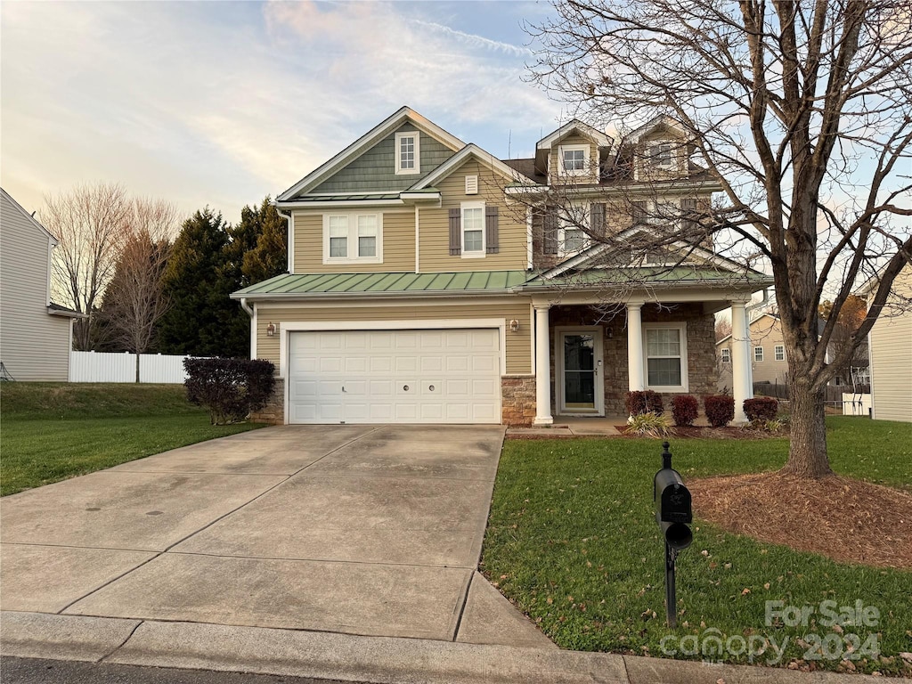 craftsman-style house featuring a yard and a garage