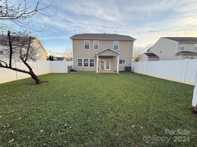 back of property featuring french doors, a patio, cooling unit, and a lawn