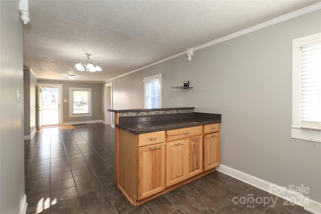 kitchen featuring a notable chandelier, kitchen peninsula, and ornamental molding