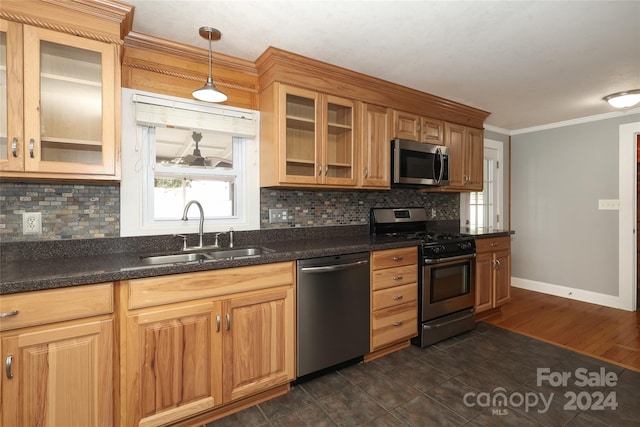 kitchen with backsplash, sink, hanging light fixtures, and appliances with stainless steel finishes