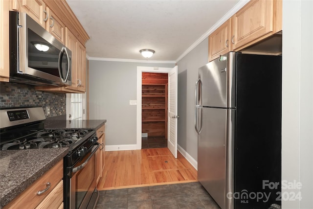 kitchen with decorative backsplash, ornamental molding, dark stone counters, stainless steel appliances, and dark wood-type flooring