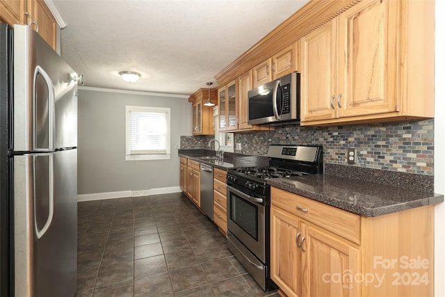 kitchen featuring backsplash, stainless steel appliances, dark stone counters, and ornamental molding