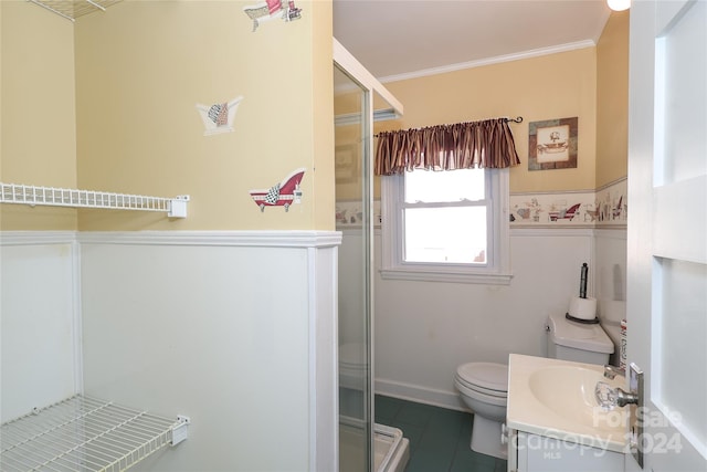 bathroom with tile patterned floors, toilet, vanity, a shower with shower door, and ornamental molding