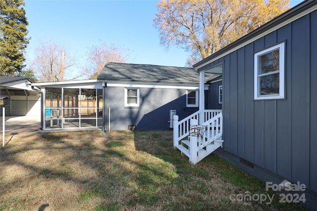 view of side of home featuring a yard and a sunroom