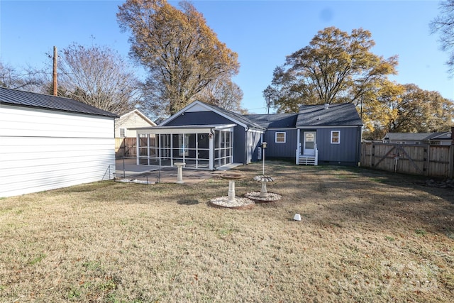 rear view of property with a patio, a lawn, and a sunroom