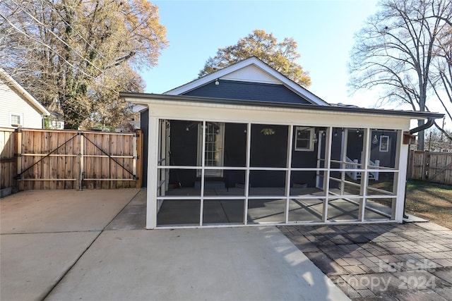 back of property featuring a sunroom and a patio